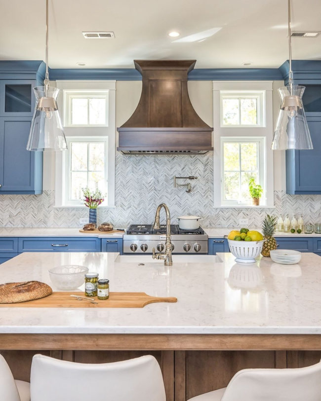 neutral glass backsplash in residential kitchen with light blue cabinetry